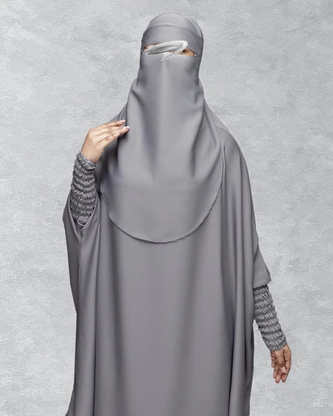 Detaillierte Ansicht des 3-teiligen Jilbab-Set in Grau mit weitem Khimar, Rock, Niqab und detailreichen, strukturierten Ärmelbündchen. In Einheitsgröße passend für kleine und große Frauen.