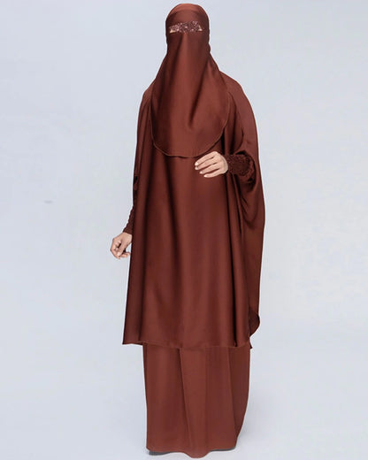 Detaillierte Ansicht des 3-teiligen Jilbab-Set in Schokobraun von vorne mit weitem Khimar, Rock, Niqab und detailreichen, strukturierten Ärmelbündchen. In Einheitsgröße passend für kleine und große Frauen. 
