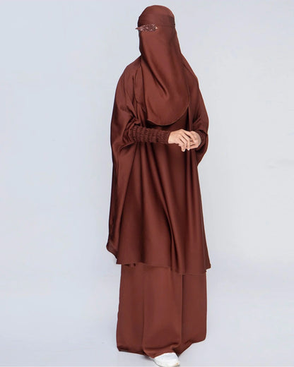 Detaillierte Ansicht des 3-teiligen Jilbab-Set in Schokobraun von der Seite mit weitem Khimar, Rock, Niqab und detailreichen, strukturierten Ärmelbündchen. In Einheitsgröße passend für kleine und große Frauen. 