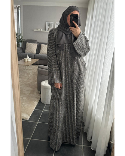 Locker geschnittene Winter-Abaya aus einem grau-schwarzen Tweed-Stoff mit weiten Ärmeln, gezeigt als komplettes Outfit mit einem passenden grauen Hijab.